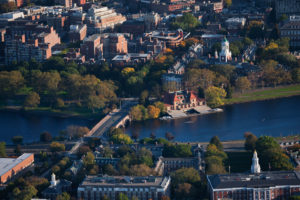 Aerial view of a city park with a lake and historic buildings.