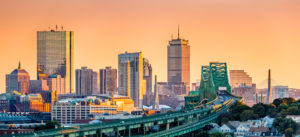 City skyline at sunset with train tracks in the foreground.